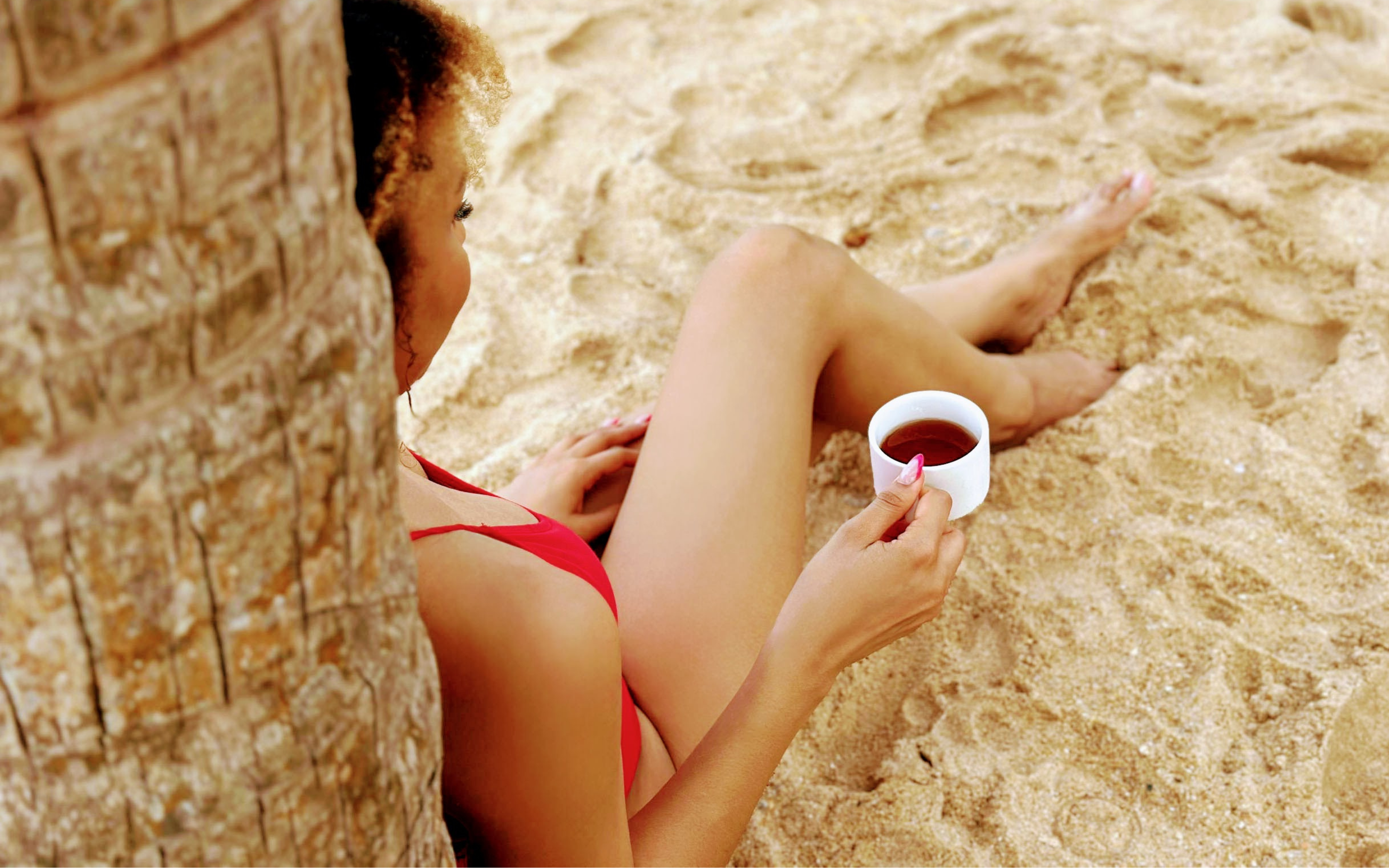 Drinking SHE KITTY tea on the beach for women's sexual health.